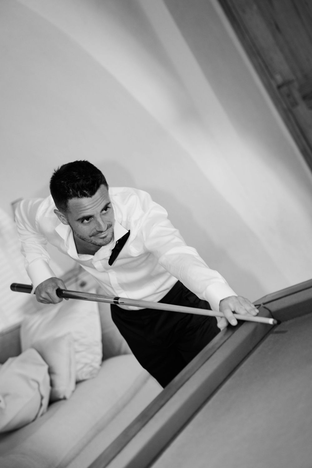 A sequence of black and white photos showing someone in a white shirt climbing up a wall or surface.
