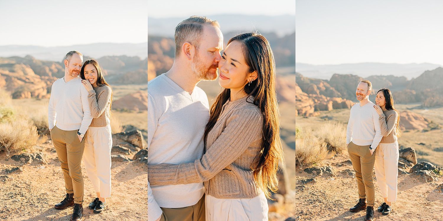 Couple embracing in a golden desert landscape during an engagement photo session with rocky terrain.