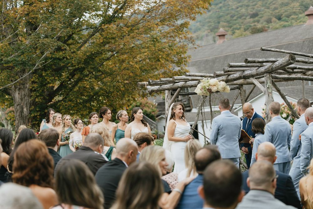 A panoramic view of an outdoor wedding ceremony in a scenic mountain setting during autumn.