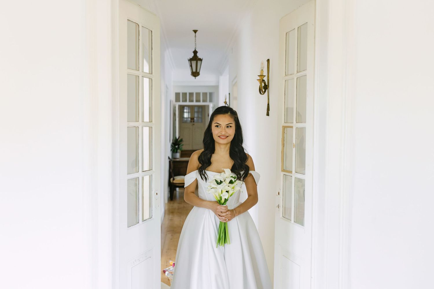 Bride holding bouquet in doorway during wedding preparations at Quinta Nova do Hespanhol Lisbon