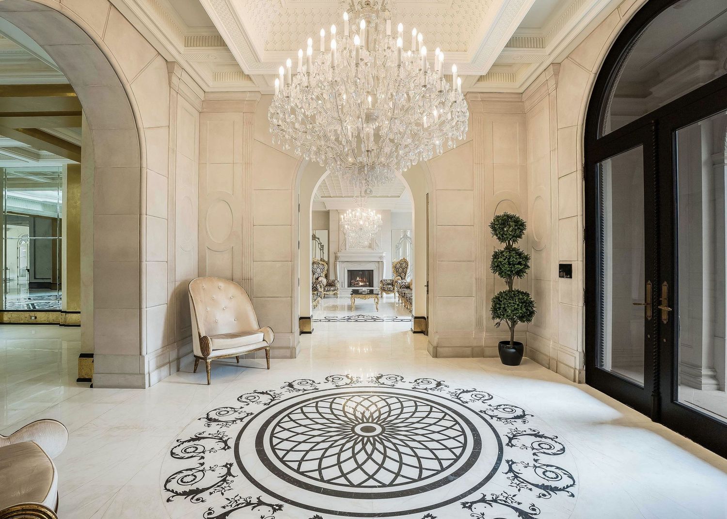 Luxurious foyer at 2275 Doulton Drive, Mississauga with crystal chandelier and intricate medallion floor pattern in classic design.