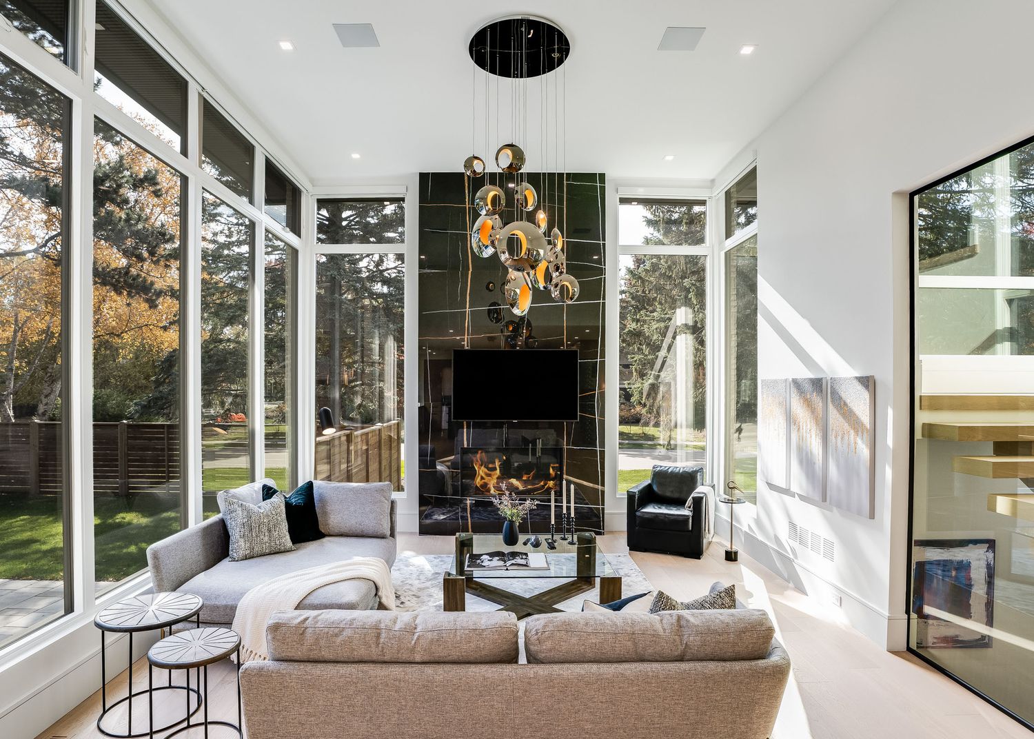 Modern bedroom with floor-to-ceiling windows, plush bedding, and contemporary furnishings in a bright, airy space.