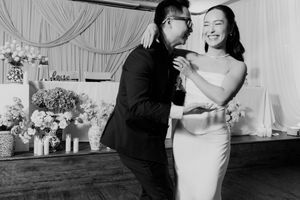 Bride and groom share a joyful first dance, smiling together at their wedding reception.