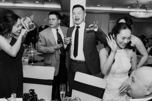 Bride and wedding guests laughing and celebrating joyfully together at the wedding reception dinner.