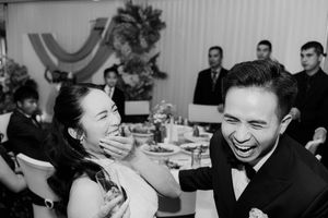 Bride and groom sharing a joyful laugh together at their wedding reception.