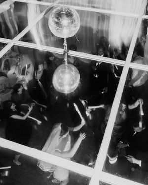 Aerial black and white view of wedding reception dance floor with disco ball and dancing guests.