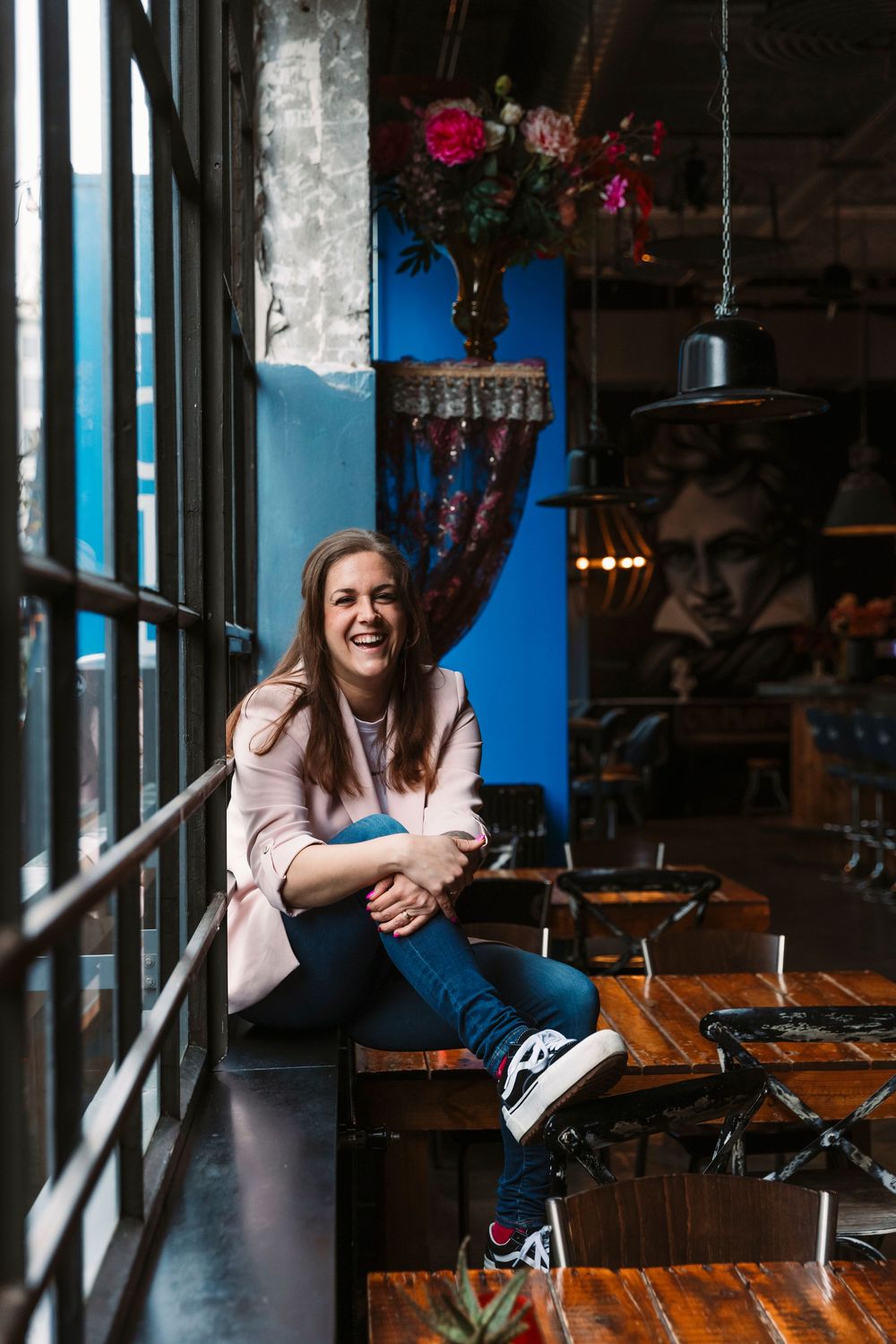 Joyful poses by window in industrial space with dramatic lighting.