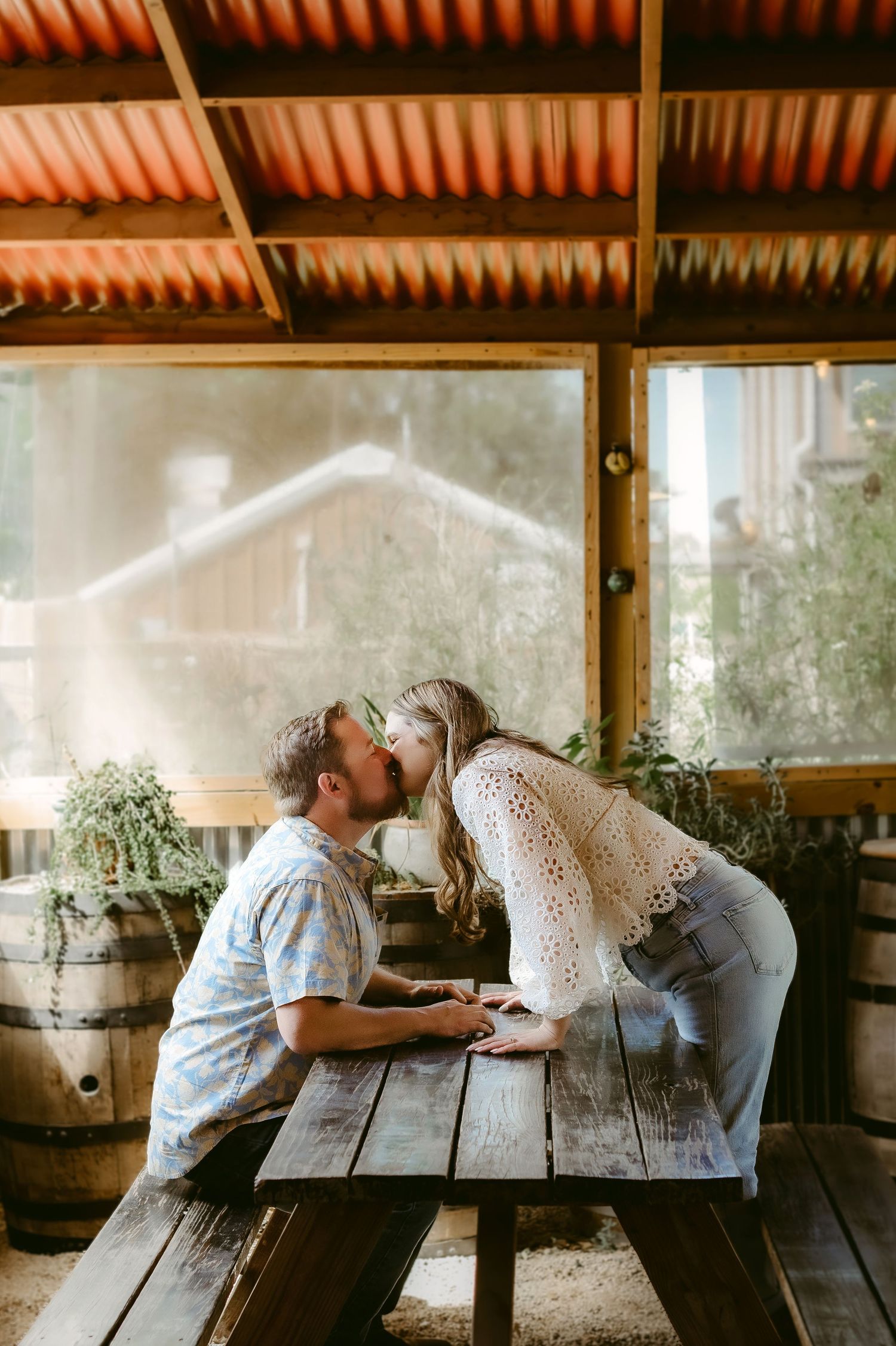 A romantic sequence of candid moments between a couple sitting at a rustic wooden table in soft natural light.
