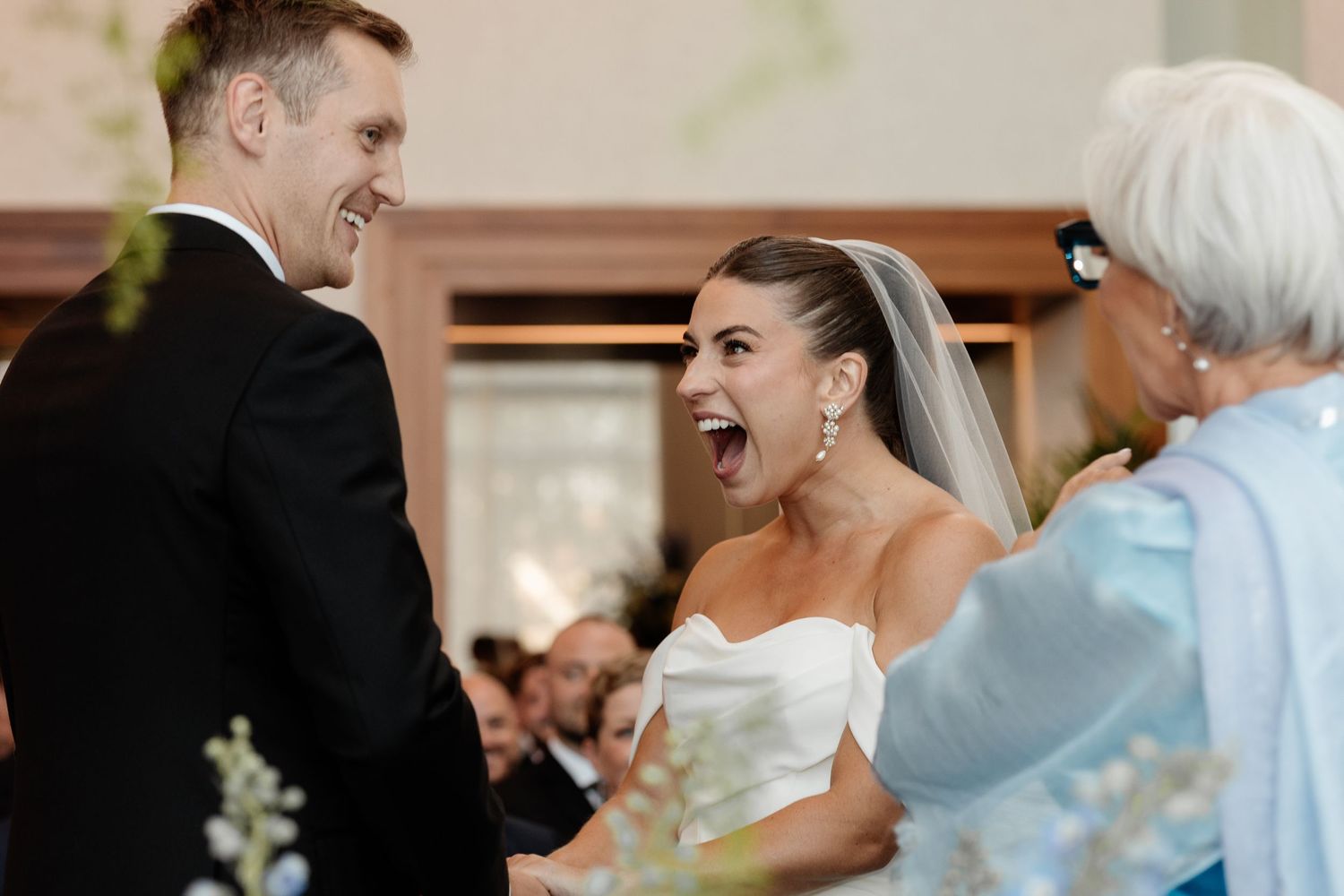 Bride laughing joyfully with groom in black suit during wedding ceremony. Candid Montreal Wedding Photography by Aliza Dworkind.