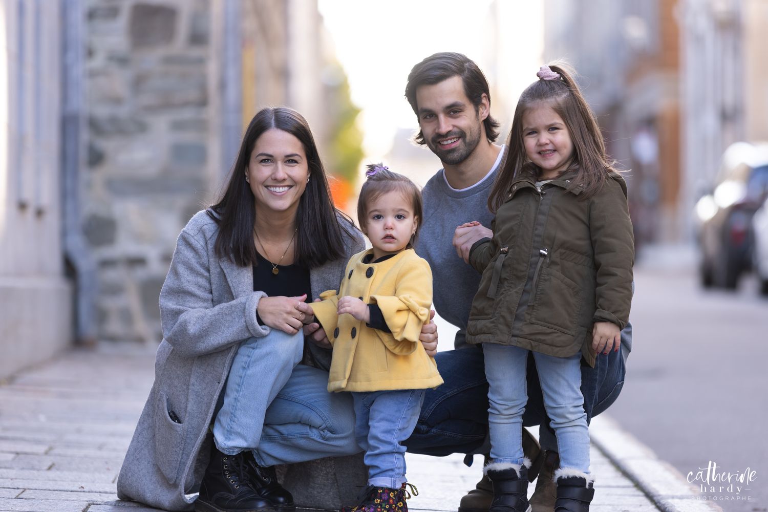 Family enjoying a playful moment together on a city street.