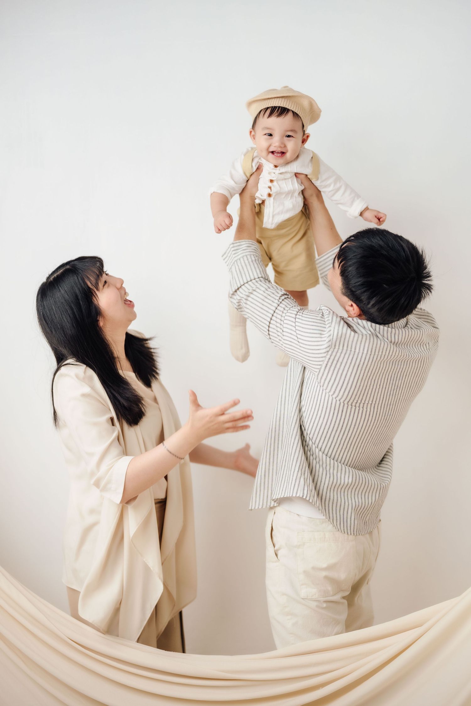 抓周寫真、全家福,渴望影像紀錄一歲寶寶抓周儀式與親子互動,透過自然光棚拍呈現溫暖氛圍,畫面包含寶寶拿取抓周物品、爬行探索與父母陪伴互動,整體風格乾淨柔和、色調溫潤,適合尋找屏東抓周寫真、全家福攝影、寶寶周歲紀念攝影的家庭參考,依照服裝而改變佈景,呈現真實自然且具故事感的家庭影像。