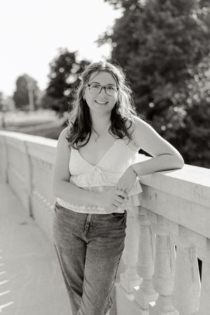 Black and white portrait series showing casual poses against a stone railing.