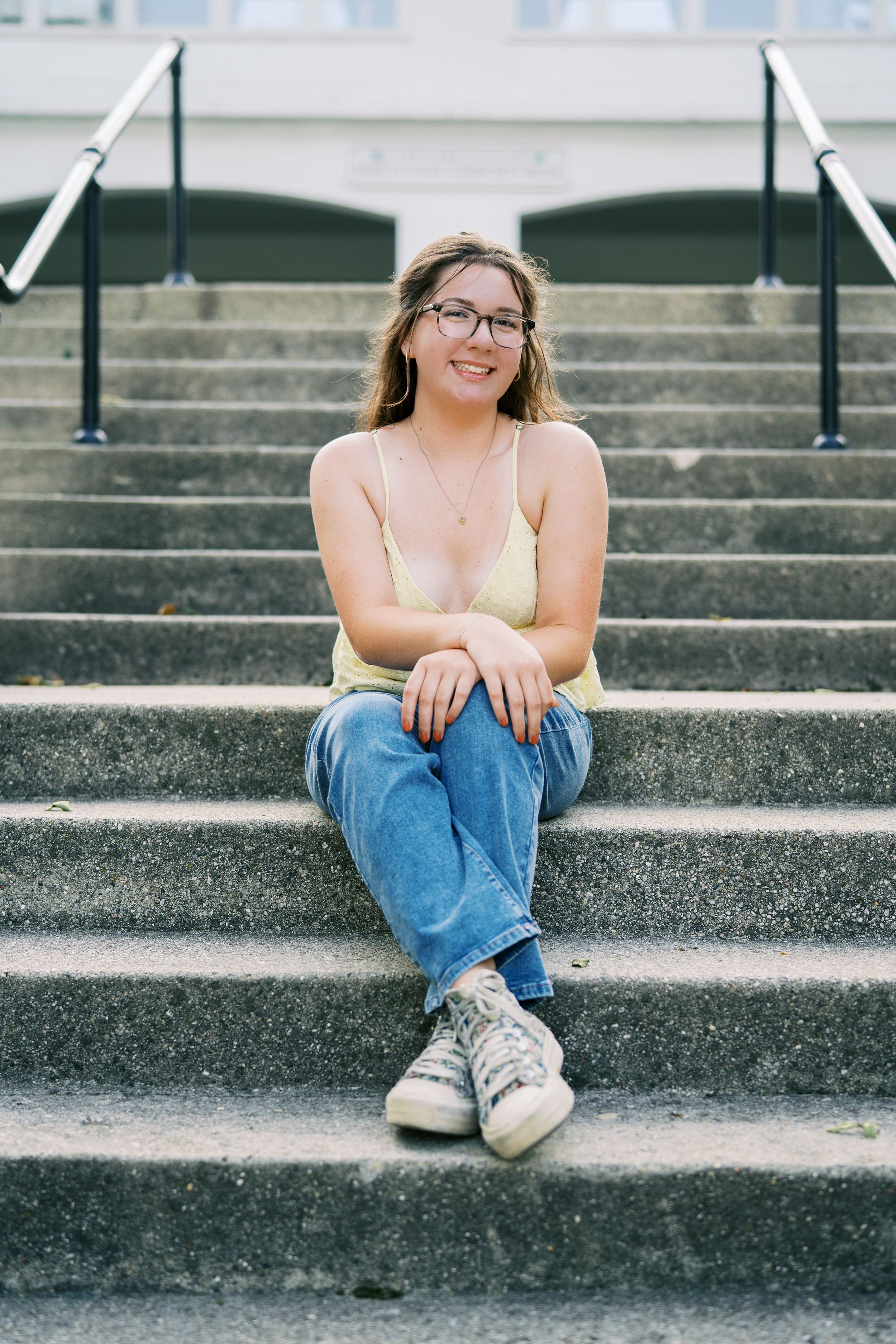 Multiple angles of someone sitting casually on grey concrete steps outdoors.
