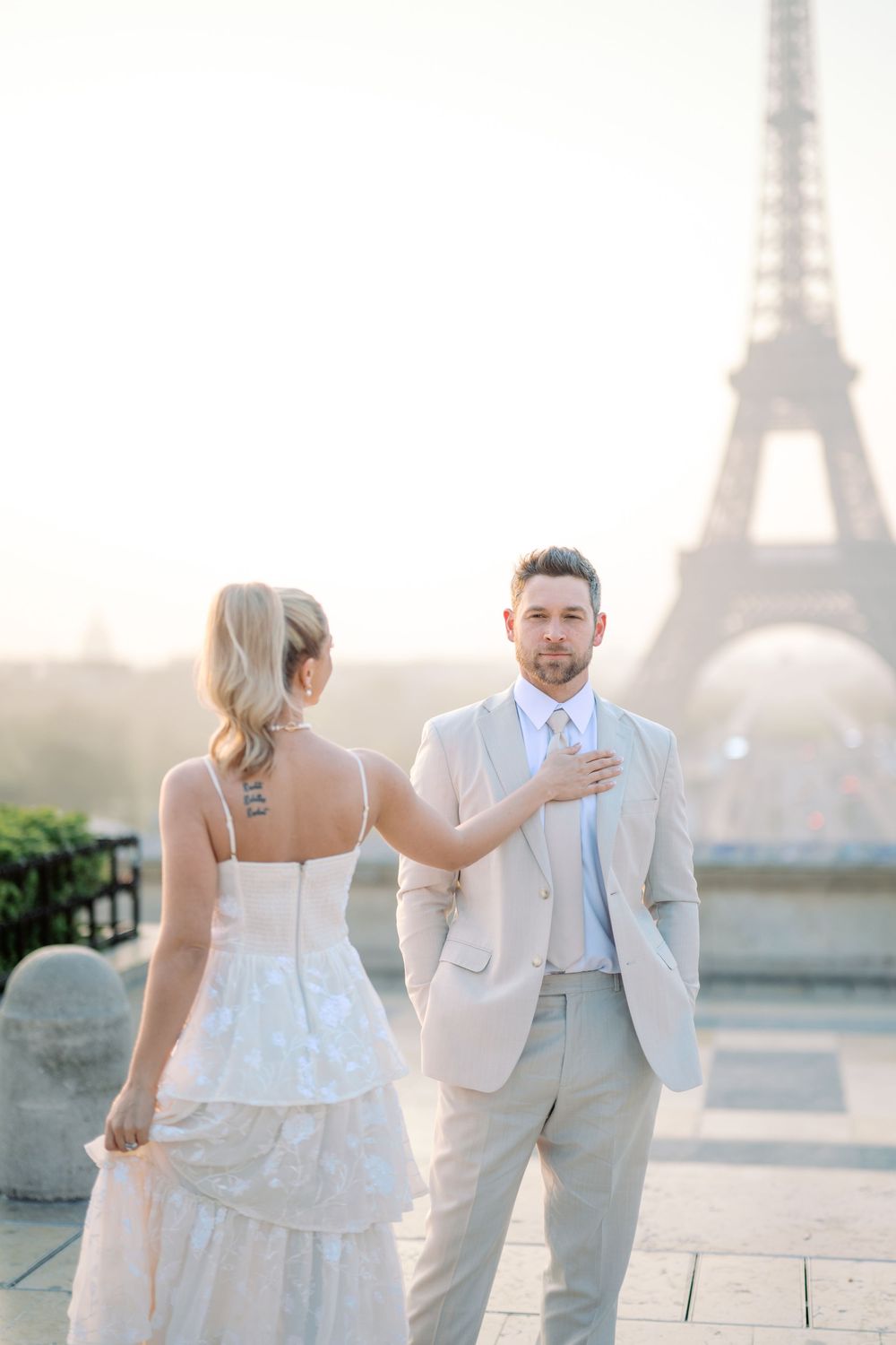 A wedding photoshoot sequence in Paris shows a couple in elegant white and grey outfits near the iconic Eiffel Tower.