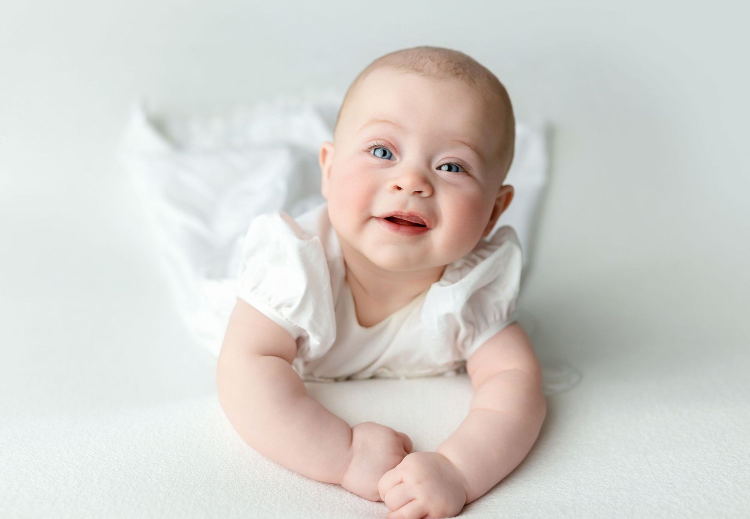 A newborn girl on her stomach grinning. Greenville SC newborn photographer, Easley SC newborn photographer, Upstate newborn photographer