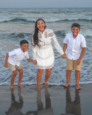 A sequence of photos showing people in white outfits playfully posing and bending down at the beach with ocean waves behind them.