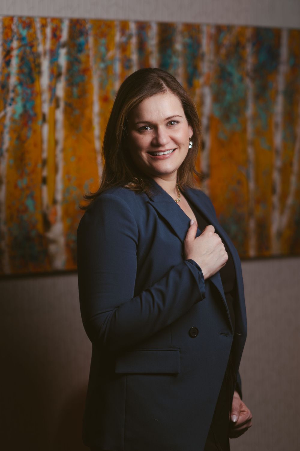 Professional headshots against orange and teal abstract wall art in studio.