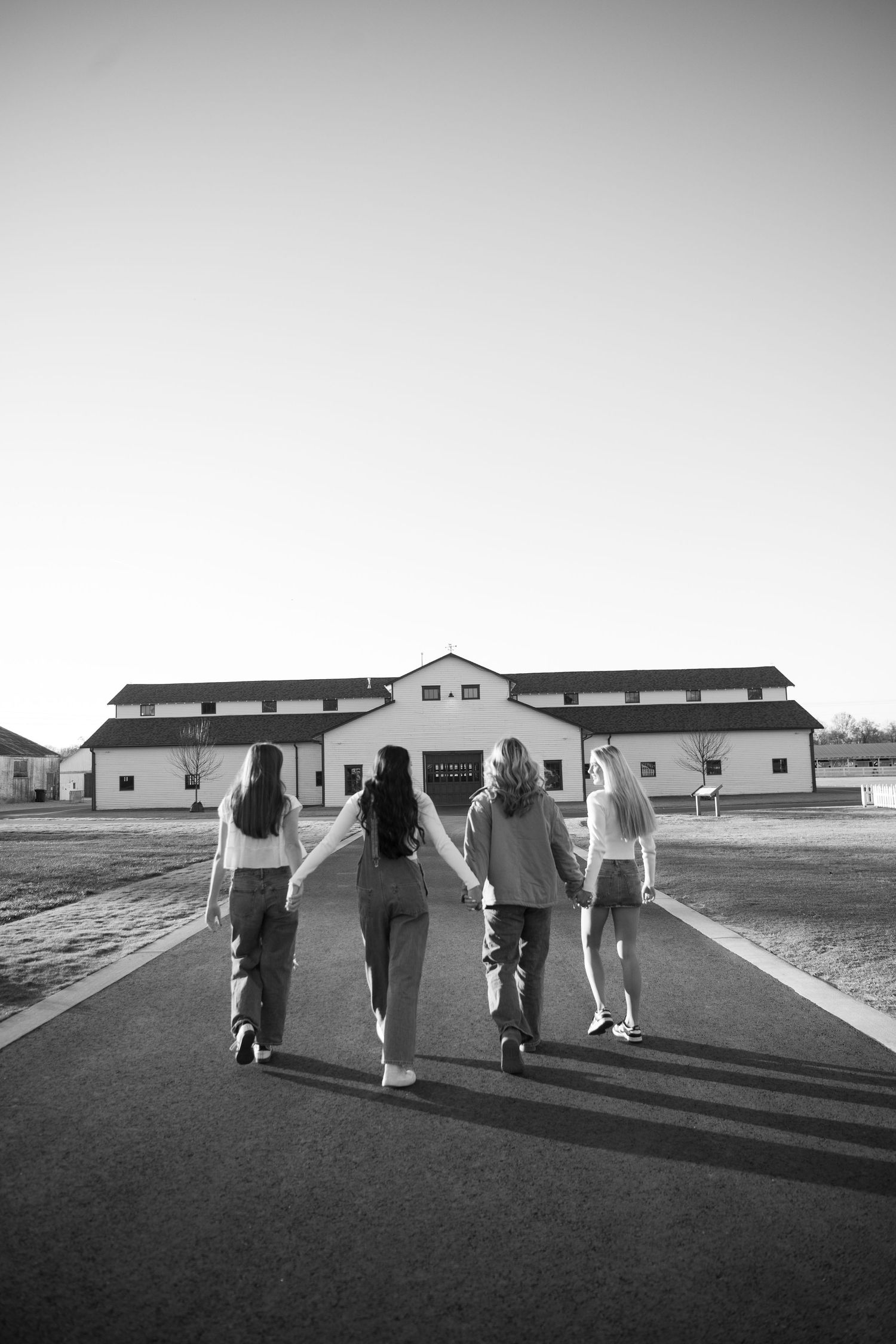 A sequence of black and white photos showing people walking away from the camera on a paved path between buildings.