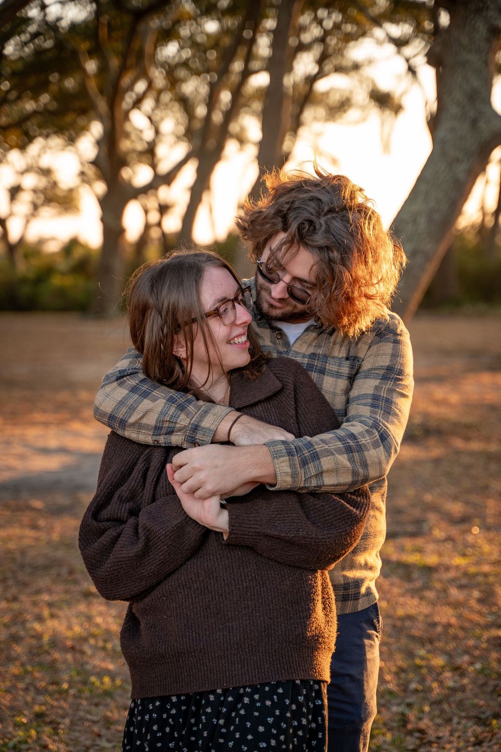 Intimate moment captured between couple hugging in late afternoon sunlight.