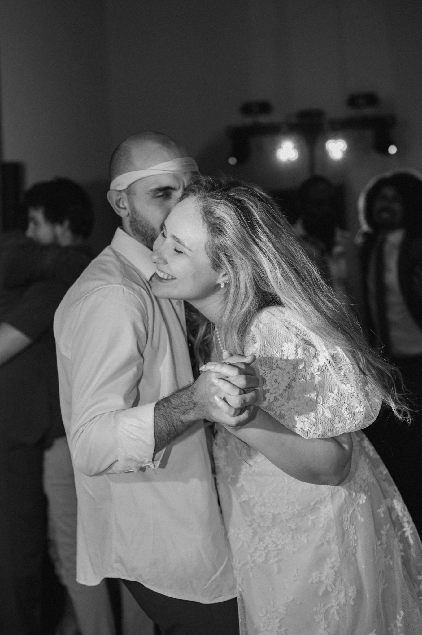 A wedding party in formal attire laughs together in a candid black and white photo sequence outdoors.