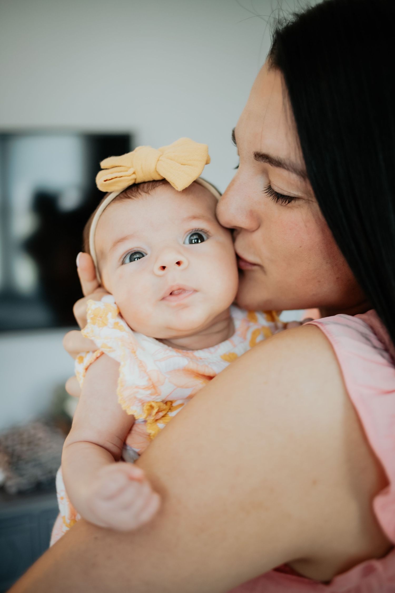 Alyssa giving her daughter a kiss on the cheek.