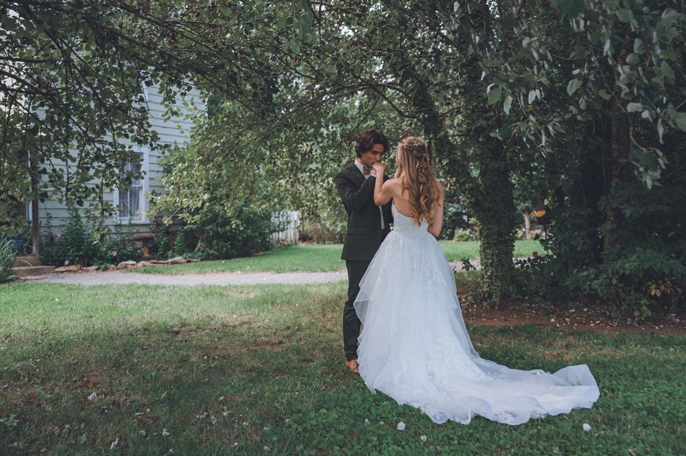 A bride and groom share a romantic moment in a lush garden setting during their outdoor wedding photoshoot.
