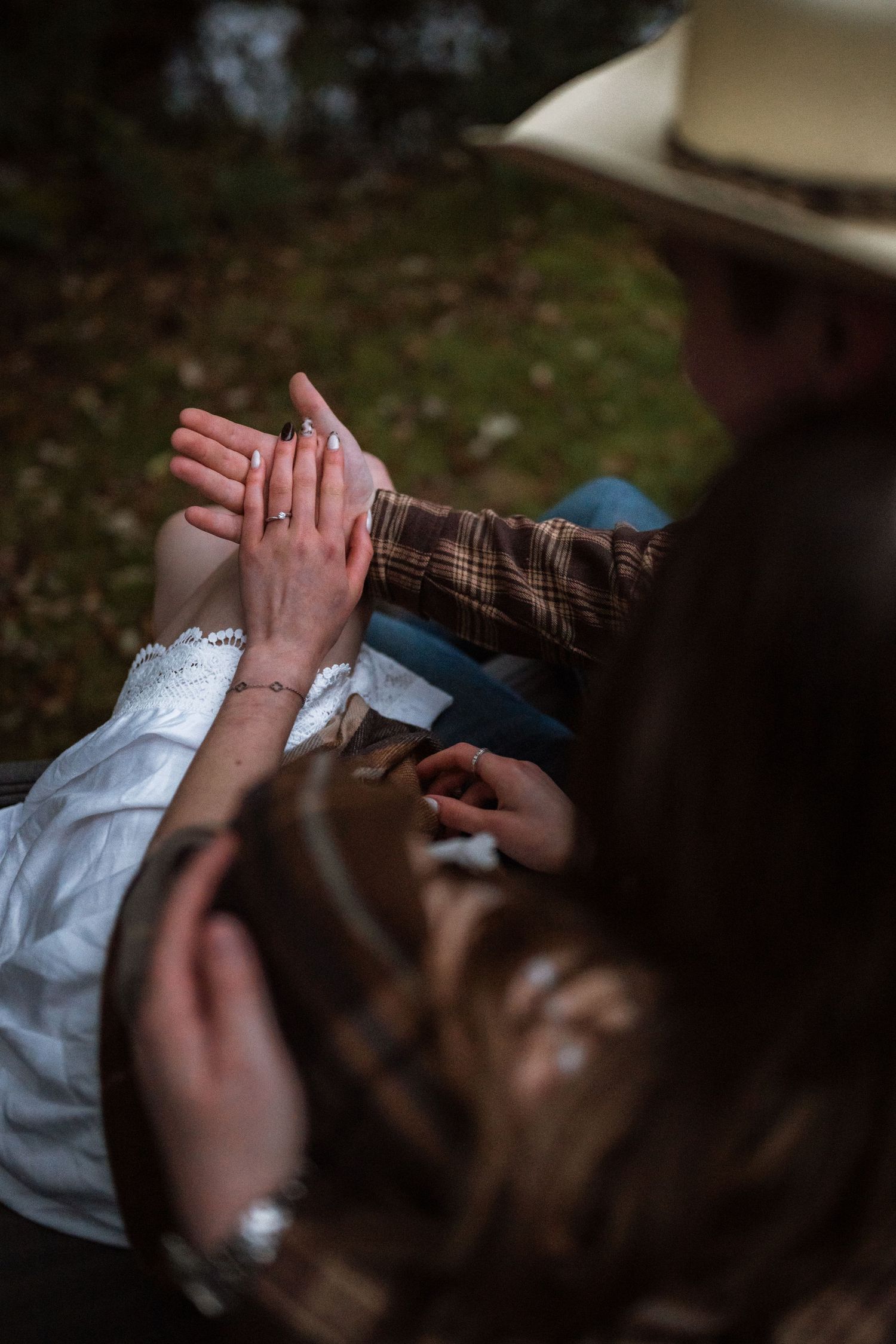 Close-up sequence of hands exchanging a small white object in natural outdoor lighting.