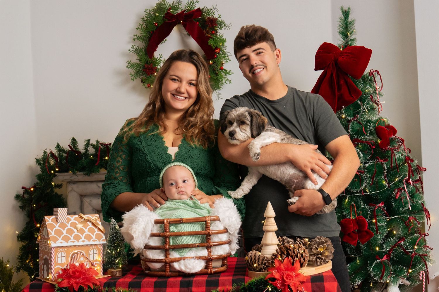 Family poses together for Christmas photos with decorated tree and festive decor.