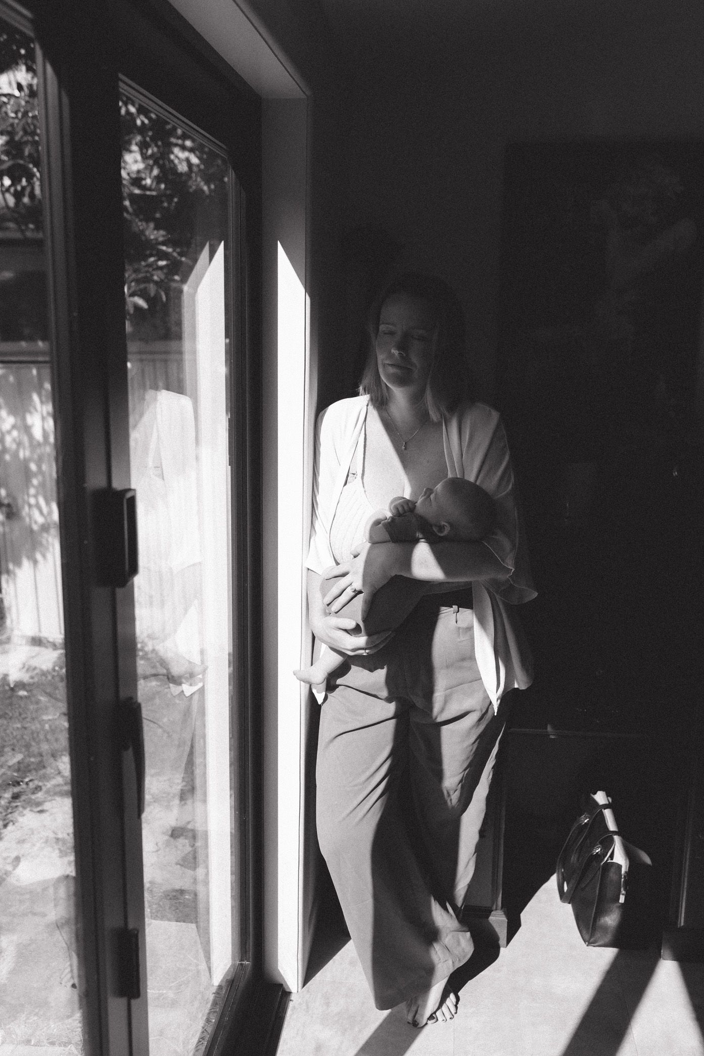 A series of four black and white photos showing a person in silhouette standing by a window.