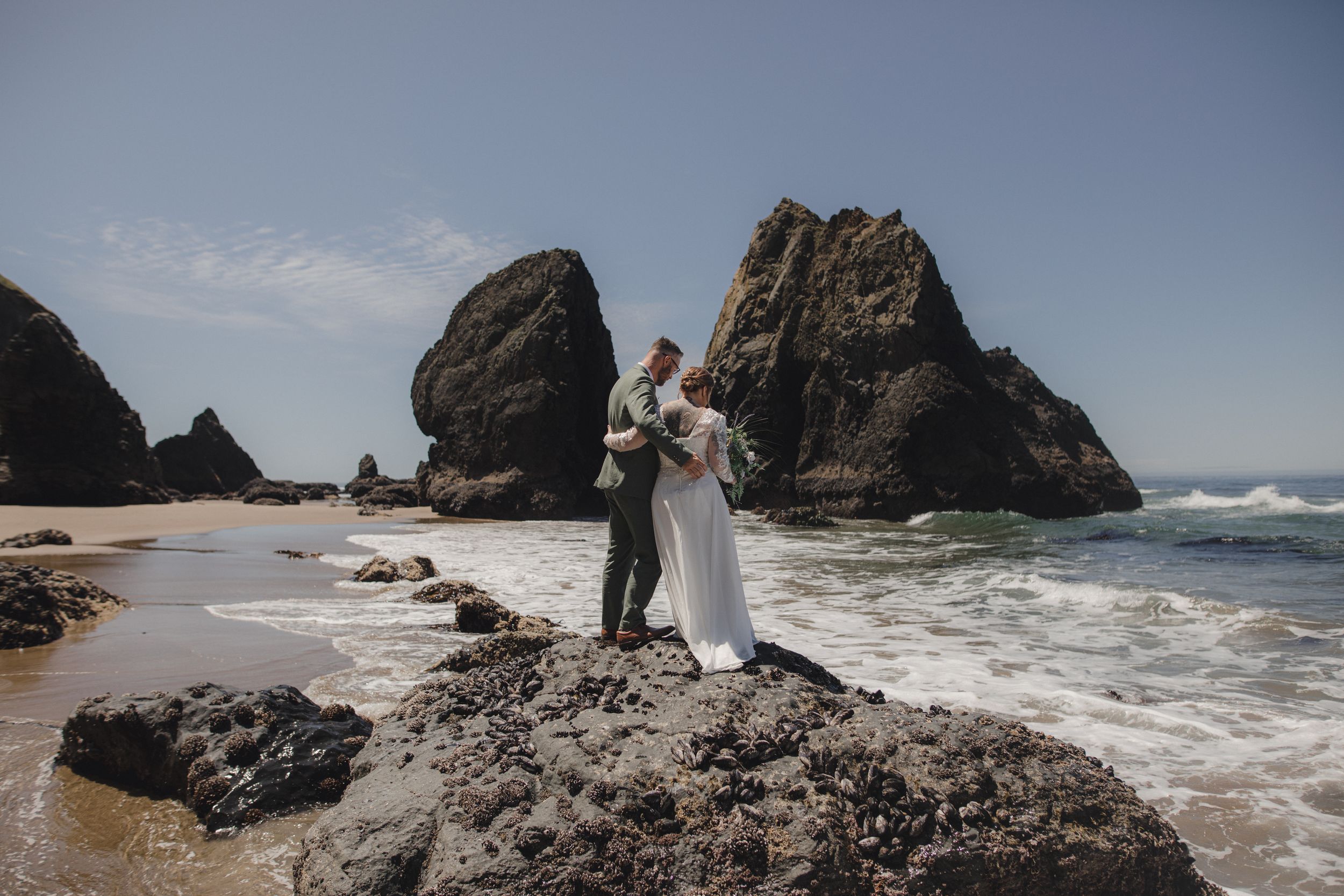 Dramatic coastal landscape with large rock formations and crashing waves along a rugged Pacific Northwest shoreline.
