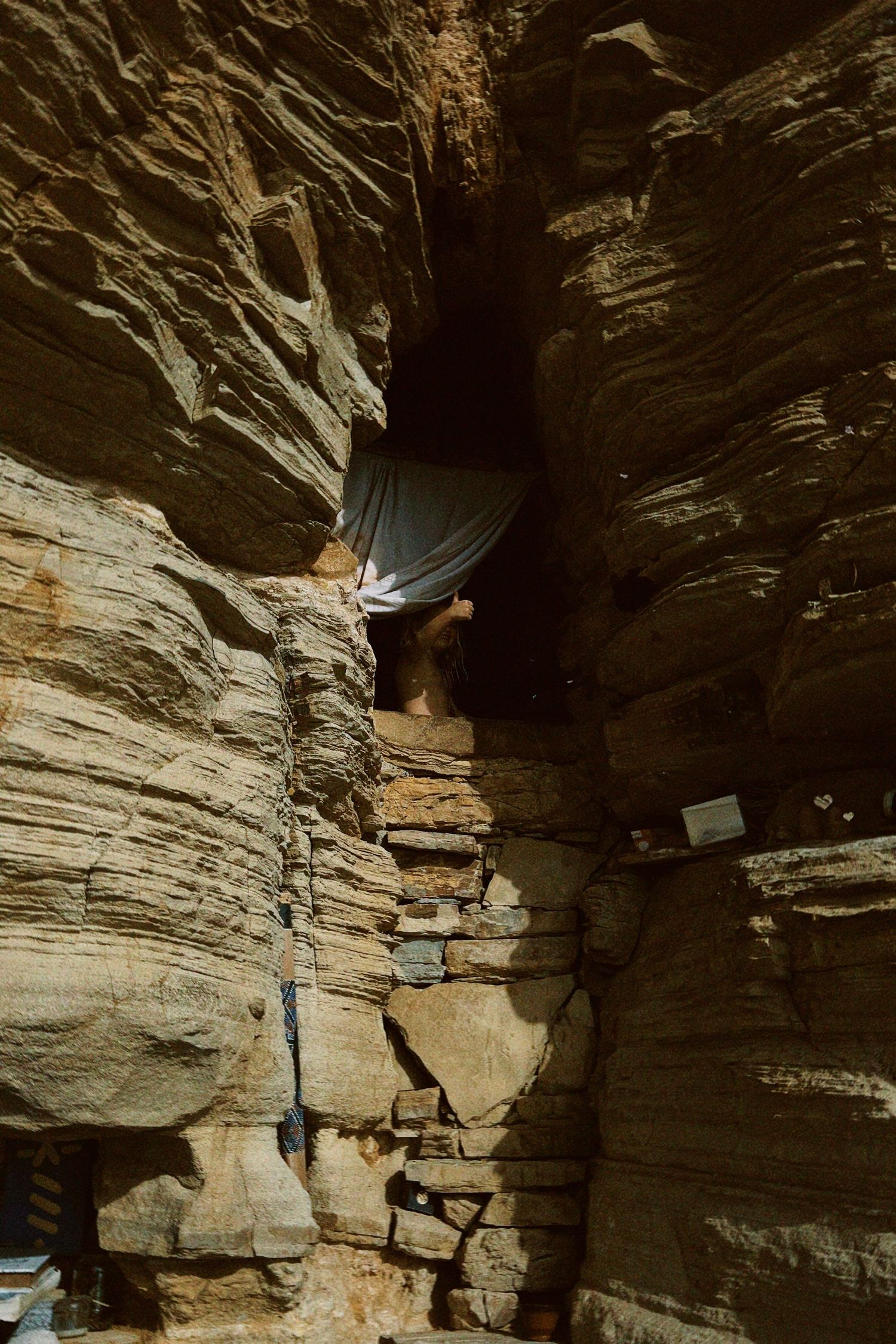 Rock climber ascending a challenging limestone cliff face using technical climbing moves and gear.
