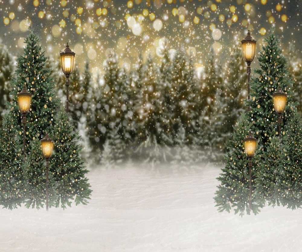 Festive winter background with bokeh lights, evergreen branches and glowing lanterns in golden tones.