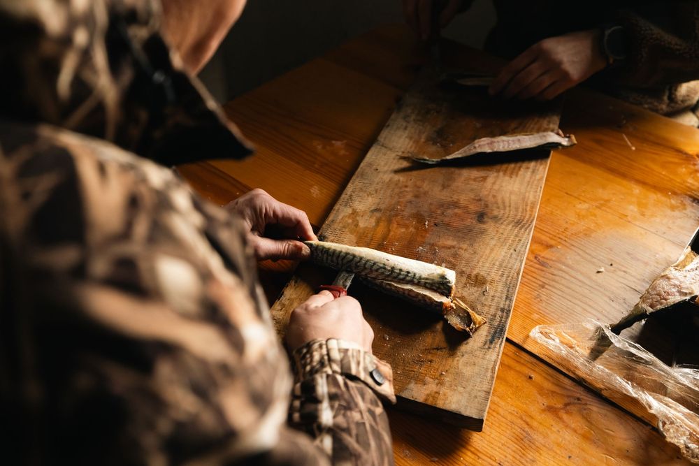 Close-up shot of hands working on a woodworking project in warm lighting on a rustic wooden workbench.