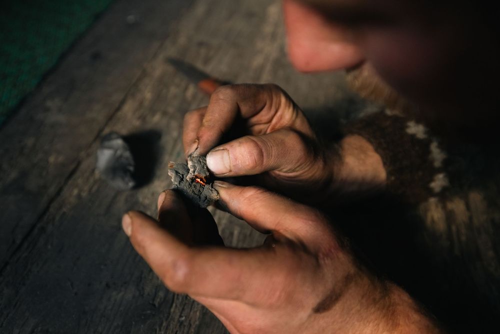 Close-up sequence showing hands using a traditional Japanese ink stone to grind calligraphy ink in circular motions.