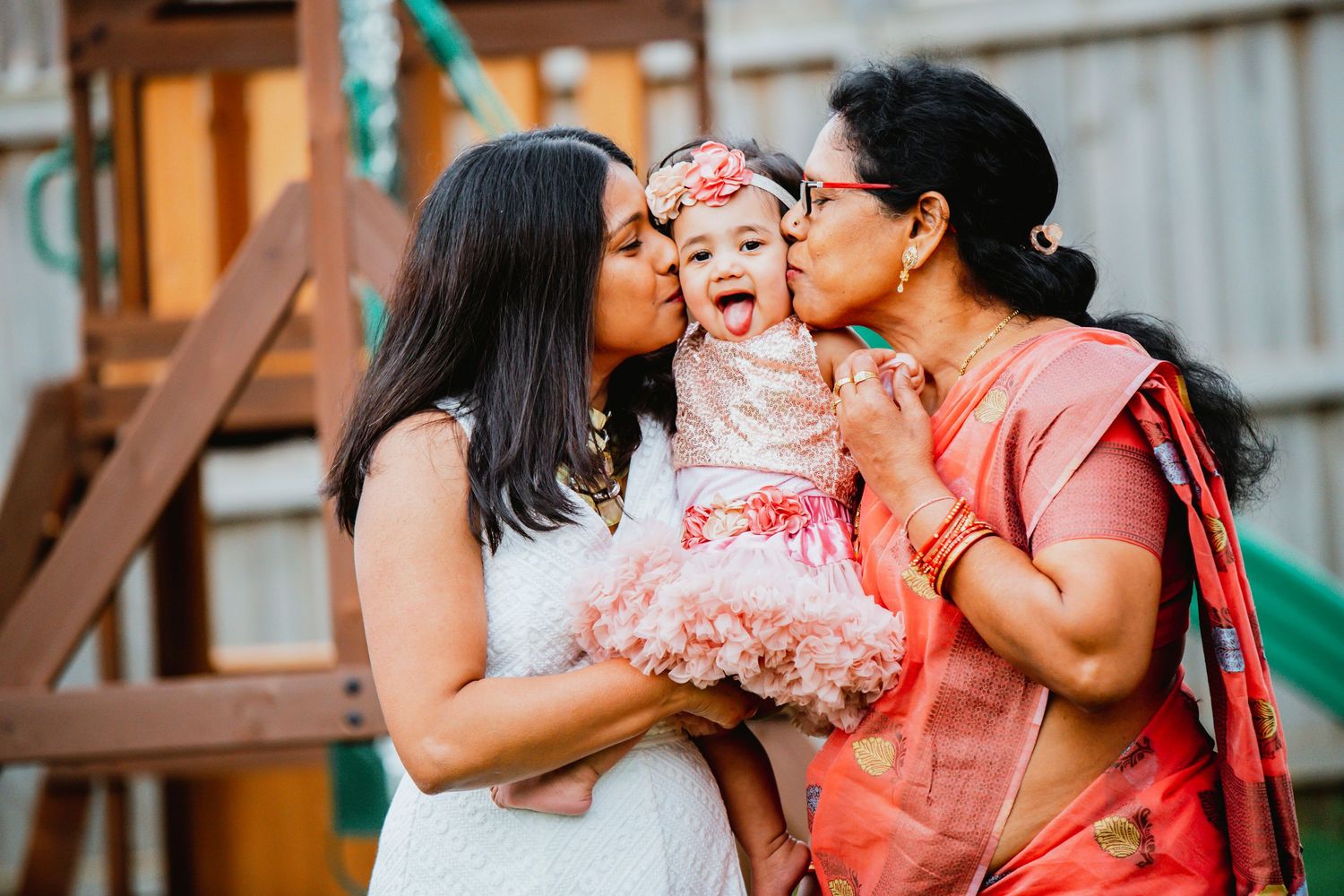 A tender family moment captured in a series of candid outdoor photos with warm lighting and coral pink accents.
