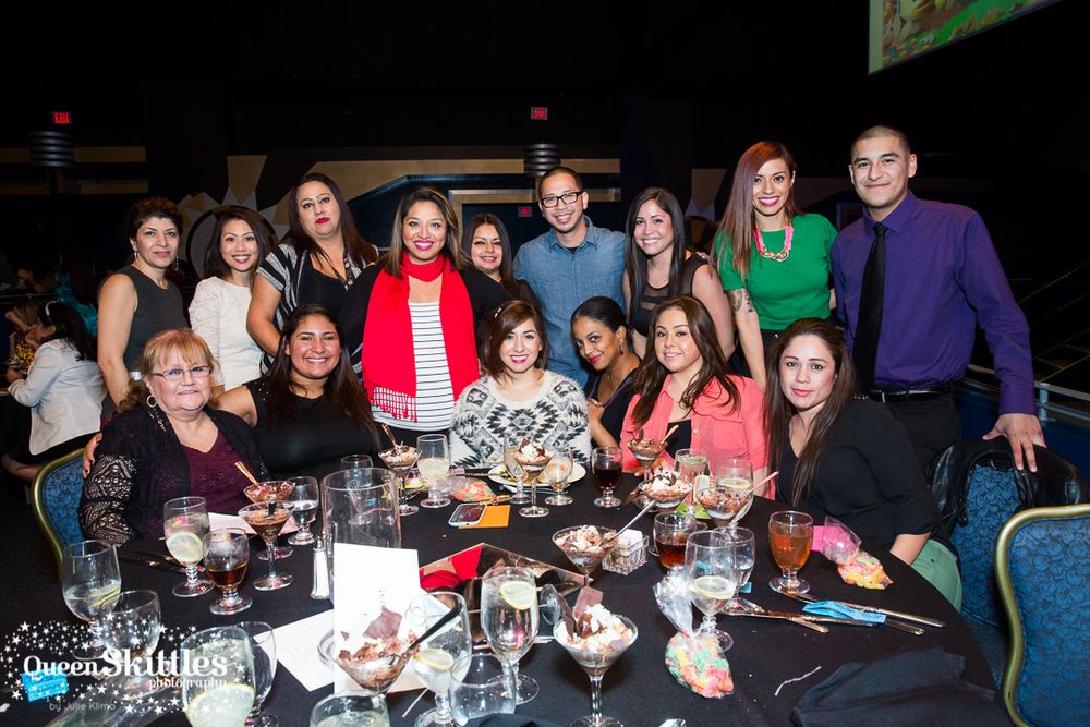 A large group gathers around a table for a celebratory dinner or social event.