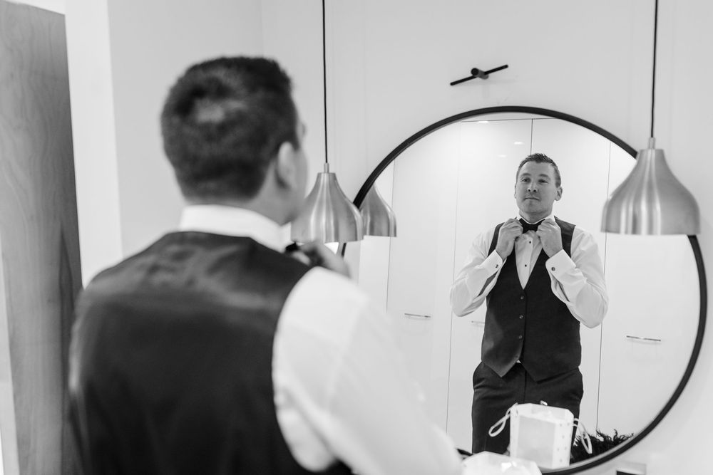 A black and white photo collage showing a person getting ready in front of a mirror wearing formal attire.