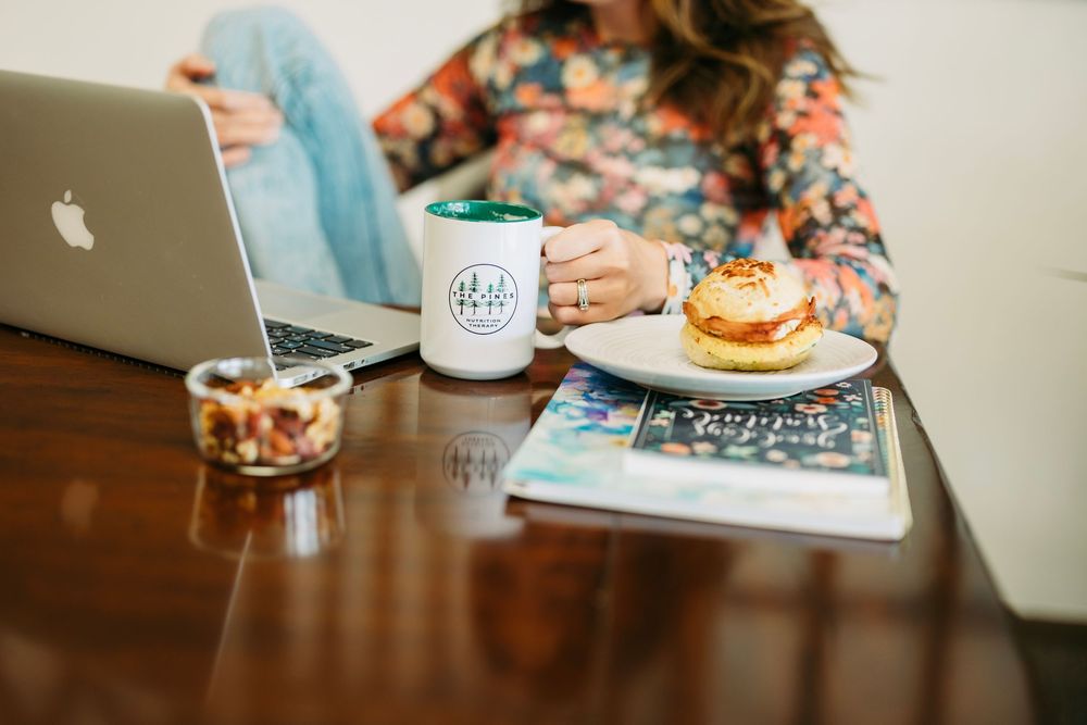 A cozy cafe scene with a person enjoying coffee and a pastry at a wooden table.