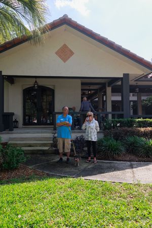 White stucco building with Spanish tile roof and covered walkway entrance.