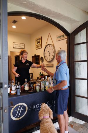 People interacting at a bar counter with Frost & Fi signage in an indoor setting.