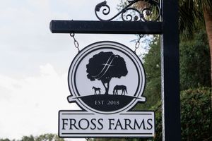 Black metal hanging sign for Fross Farms featuring silhouettes of a tree and horse established in 2018.