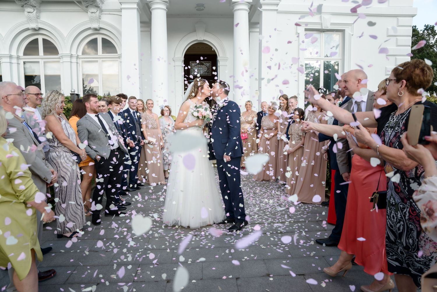 Bride and groom with guests during a confetti shower outside Runcorn Town Hall by Cheshire wedding photographer Michael Pardoe