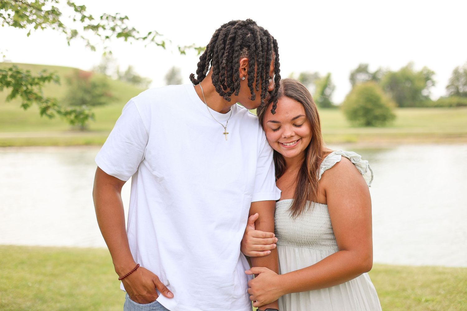 Springfield, IL Photographer captures a couple snuggled together in front of a pond at Centennial Park