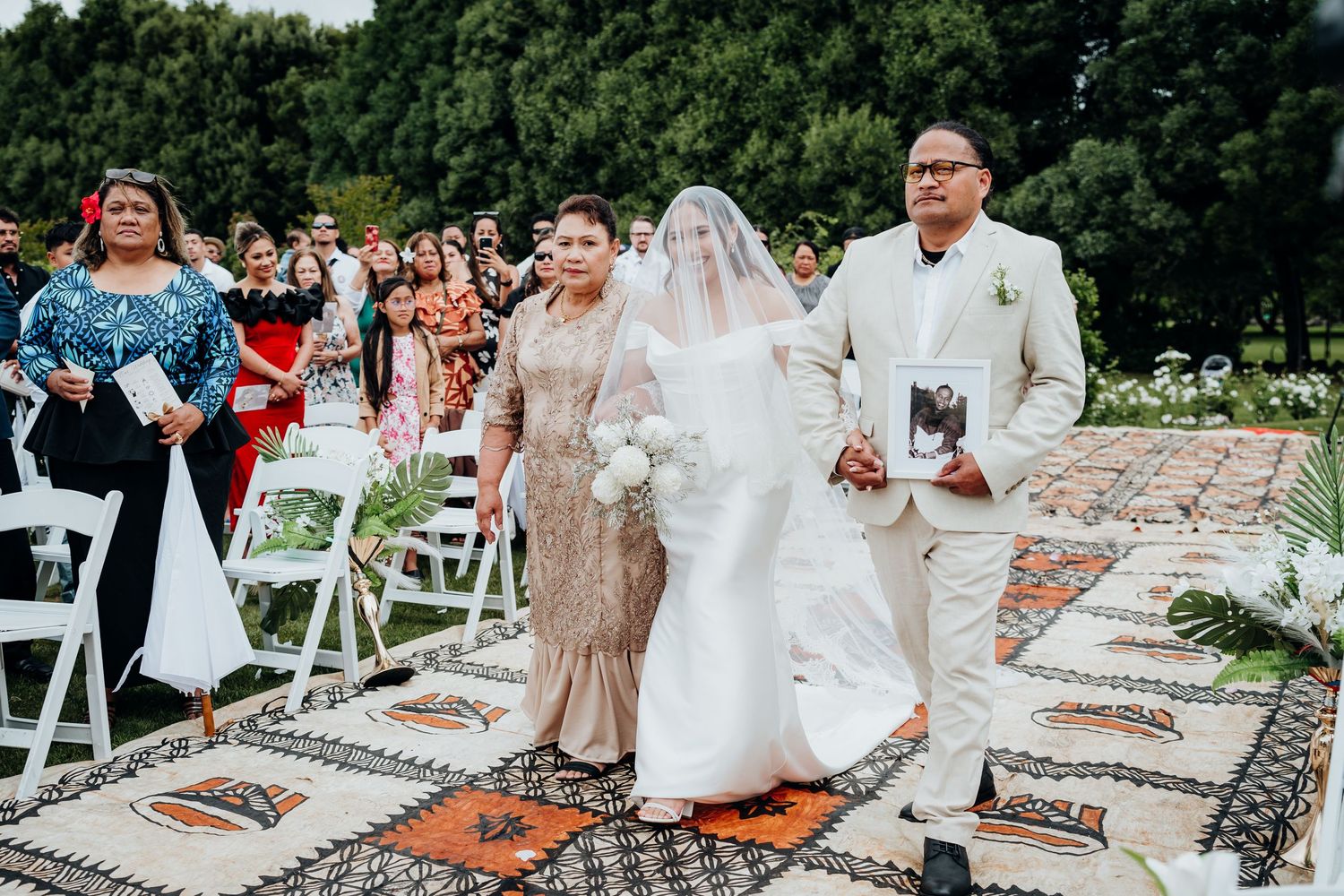 Wedding guests toss colorful confetti in celebration during an outdoor ceremony.