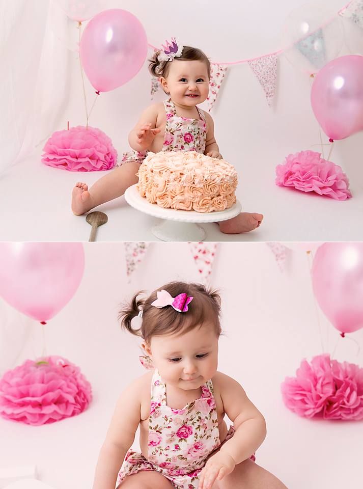 First birthday cake smash setup with floral dress, pink decorations and ruffled cake.