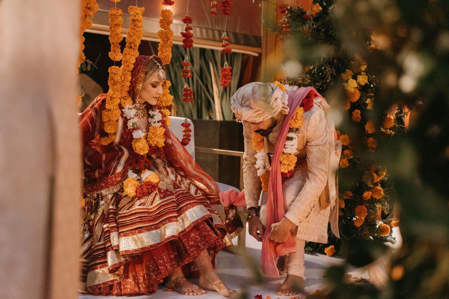 Elegant wedding ceremony setup with warm lighting and orange floral arrangements creating a romantic ambiance.