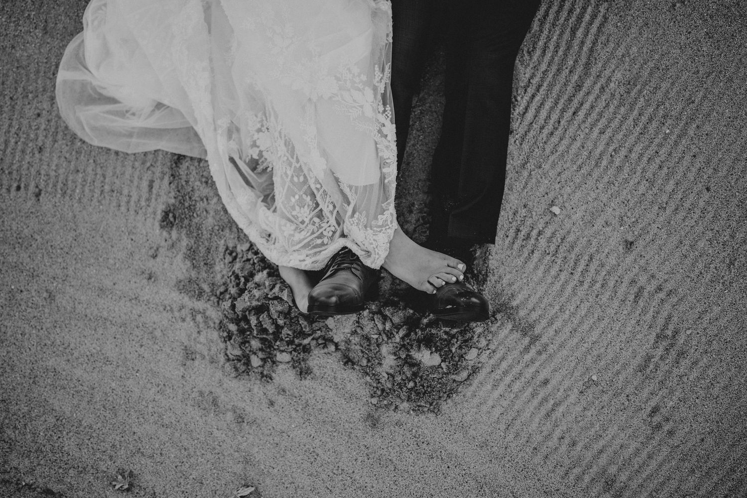 A black and white photograph shows feet with traditional henna designs in an artistic composition.