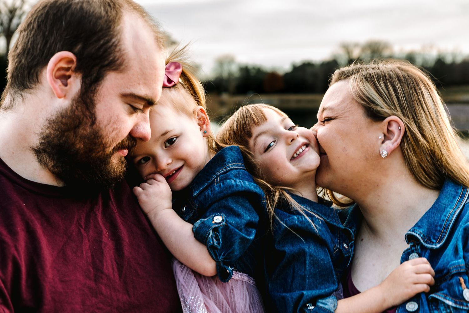 A family plays together in shallow river water on a sunny day, creating splashes and sharing joyful moments.