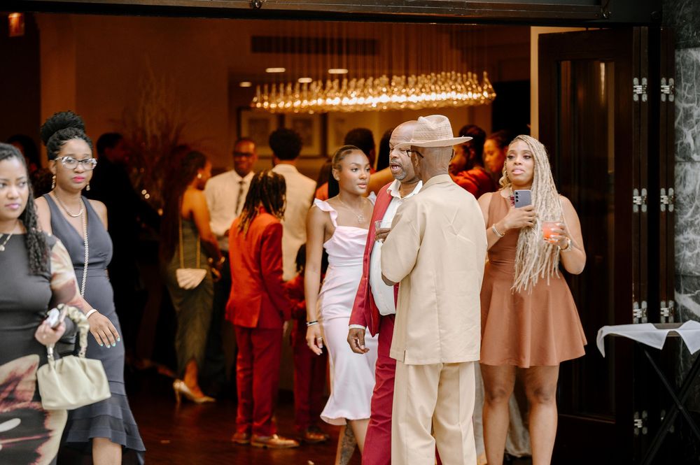 People dancing together in an indoor venue with warm lighting and wooden floors.