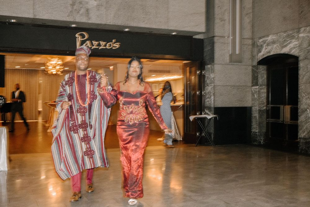 People walking through a modern building hallway with concrete walls and bright lighting.